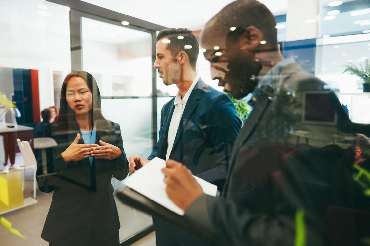 Procurement team reviewing a vendor risk assessment behind a glass office wall in Dubai